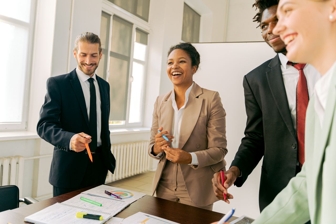 The Art of Drawing Readers In: Your attractive post title goes here A diverse group of professionals collaborating in a bright office setting, engaging in teamwork and discussion.